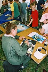 Carolyn Grace signs her picture in the calendar.